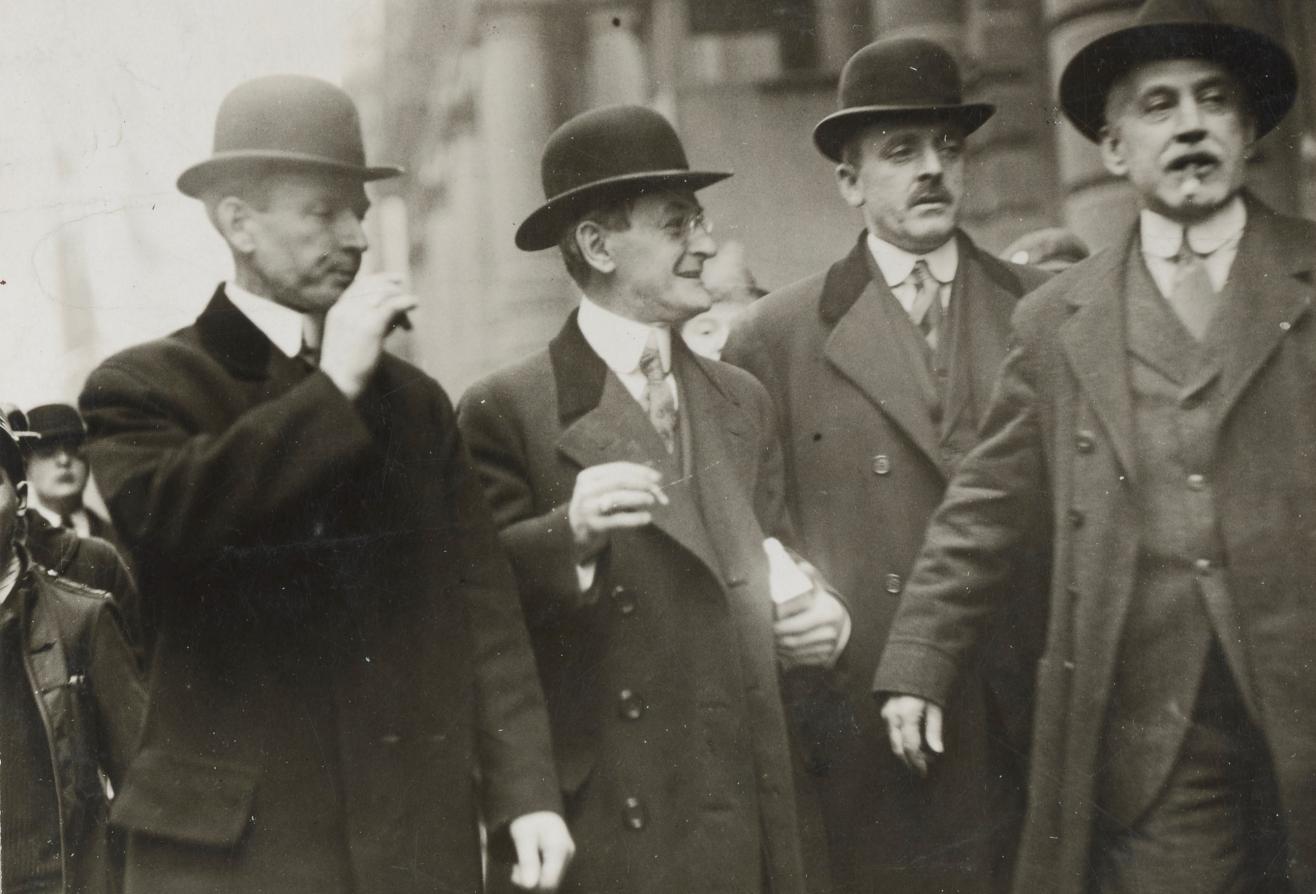 Photograph of three U.S. marshals escorting Carl Muck from the Federal Building in Boston in 1918.